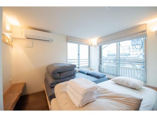two beds in a room with a balcony at bmj Hyakunincho - Vacation STAY 46879v in Tokyo