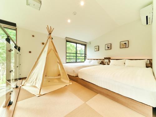 a bedroom with two beds and a tent at Rakuten STAY VILLA Hakone Sengokuhara South Wing 103 BBQ Terrace capacity of 10 persons in Hakone