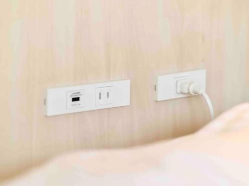a bedroom with a bed and two outlets on the wall at Murao Building 3F, 4F - Vacation STAY 51102v in Takamatsu