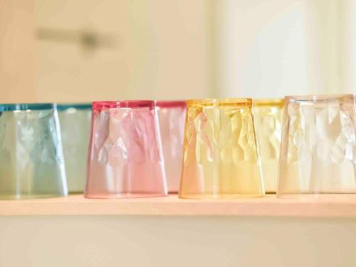 a row of different colored glasses sitting on a shelf at Murao Building 3F, 4F - Vacation STAY 51102v in Takamatsu