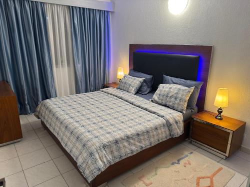 a bedroom with a bed with a blue light on it at Charmant T2 Lumineux Spacieux Vieux Cocody Centre in Abidjan