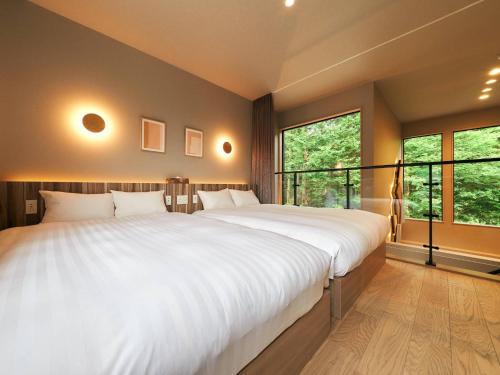 a bedroom with two large white beds and windows at Rakuten STAY VILLA Hakone Sengokuhara North Wing 104 BBQ Terrace with Massage Chair capacity of 10 persons in Hakone