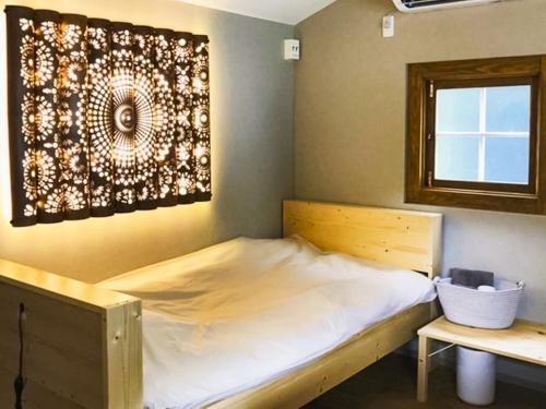 a bed in a room with a picture on the wall at the room - Vacation STAY 79941v in Kannoura