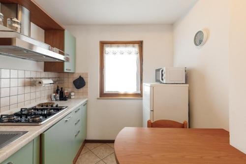 a kitchen with a white refrigerator and a table at Dolomitohouse PEZ in Fiera di Primiero