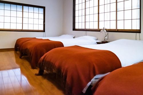 a group of four beds in a room with windows at iORi Yufuin - Vacation STAY 42351v in Yufuin