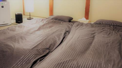 an unmade bed in a bedroom next to a lamp at Kawachi no Yado - Vacation STAY 41785v in Kawachinagano