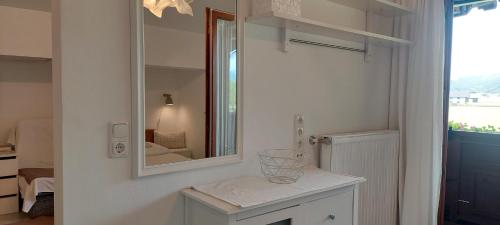 a white bathroom with a mirror and a counter at Abis Ferienwohnung Salzkammergut in Strobl