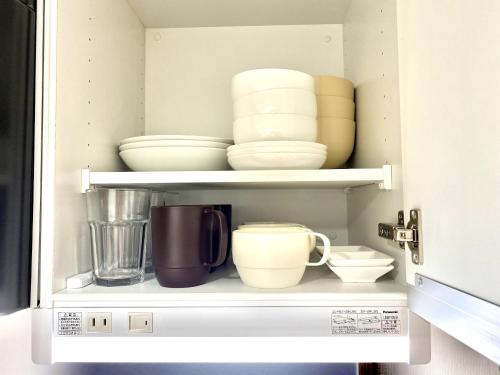 a cupboard filled with bowls and other dishes at Le Soleil Asato - Vacation STAY 48667v in Naha