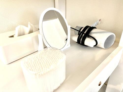 a mirror and a toothbrush in a holder on a shelf at Le Soleil Asato - Vacation STAY 48667v in Naha