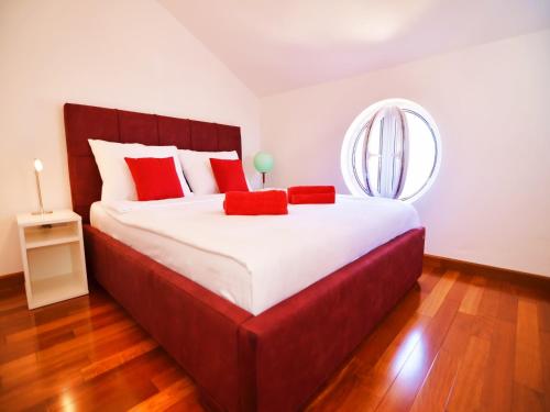 a bedroom with a large bed with red pillows and a mirror at Luxurious Villa in Murter with Pool in Murter