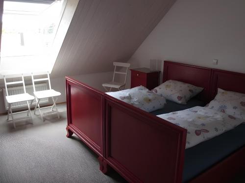 a bedroom with a bed and chairs and a window at Ferienwohnung Stine in Stetten