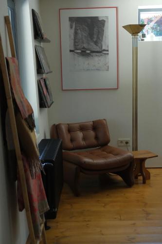 a living room with a brown leather couch and a lamp at Frank86 in Băile Tuşnad