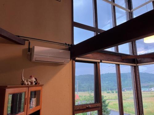 a room with windows with a view of a mountain at Sanso Harunoki staff-resident type - Vacation STAY 11615 in Furano