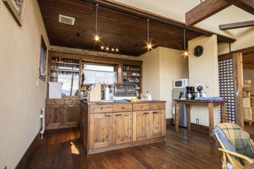 a large kitchen with wooden cabinets and a counter at Sanso Harunoki staff-resident type - Vacation STAY 11615 in Furano