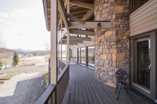 a porch of a house with a stone wall at Sanso Harunoki staff-resident type - Vacation STAY 11615 in Furano
