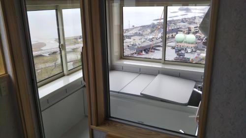 a window seat in a room with a view of a city at Nihonkai Nou no yado Miharashitei - Vacation STAY 11631 in Itoigawa