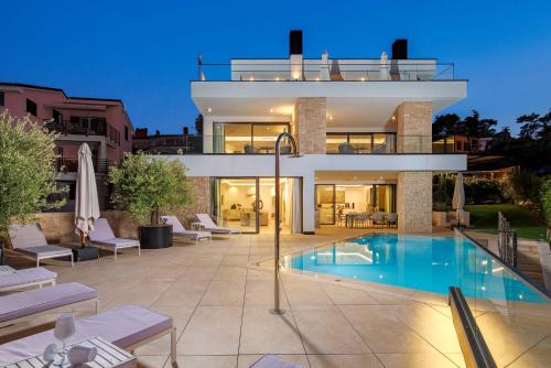 a villa with a swimming pool at night at Villa Albion in Rovinj