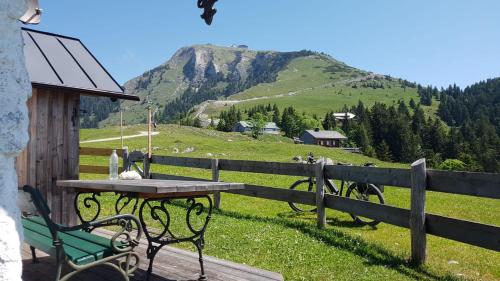 a picnic table and bench in front of a fence at Abis Ferienwohnung Salzkammergut in Strobl
