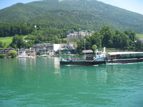 a large boat in the water near a city at Abis Ferienwohnung Salzkammergut in Strobl