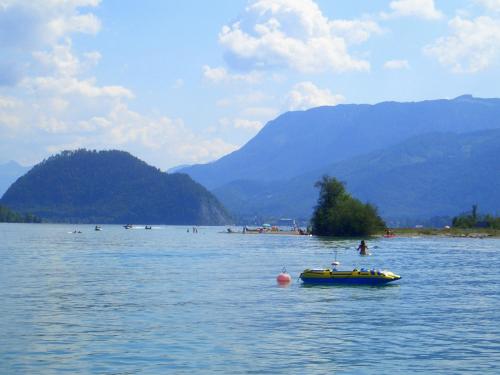 a small boat in the middle of a body of water at Abis Ferienwohnung Salzkammergut in Strobl