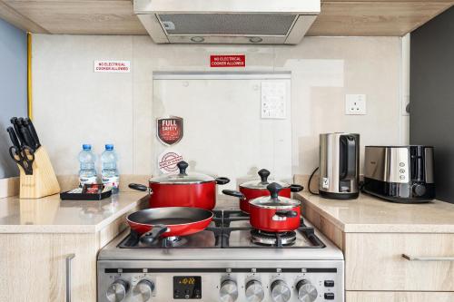 two pots and pans on a stove in a kitchen at Unlock Metropolis Business Bay in Dubai