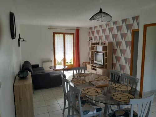 a kitchen and living room with a glass table and chairs at Jolie maison à la campagne avec Spa et piscine in Bussac
