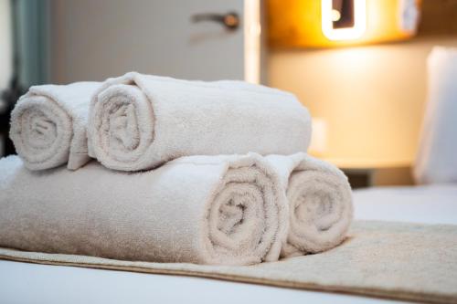a pile of towels sitting on top of a bed at Huelin Edificio Apartamentos in Málaga