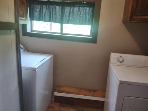 a bathroom with a washing machine and a window at Home Place in McArthur