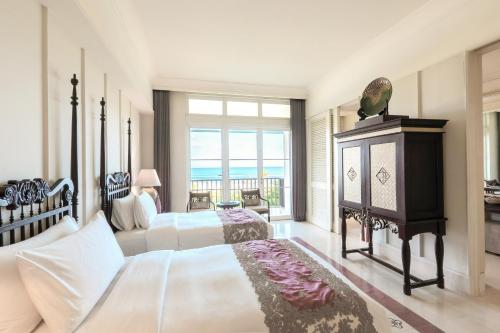 a bedroom with two beds and a view of the ocean at Rumah Luwih Bali in Keramas