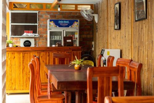 a dining room with a wooden table and chairs at Travellers Inn in Phumĭ Réach Born