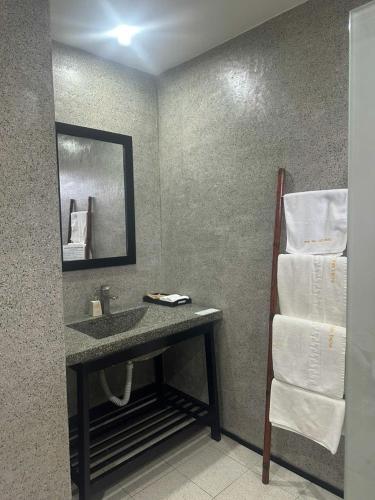 a bathroom with a sink and a mirror and towels at Phong Nha Lake House Resort in Phong Nha