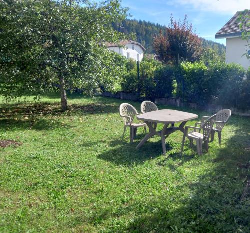 a picnic table and chairs in the grass at Martignat Les Chats 