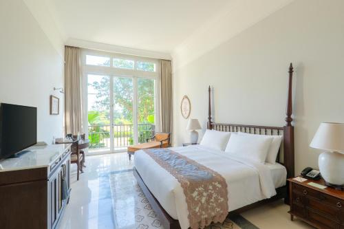 a bedroom with a large bed and a television at Rumah Luwih Bali in Keramas