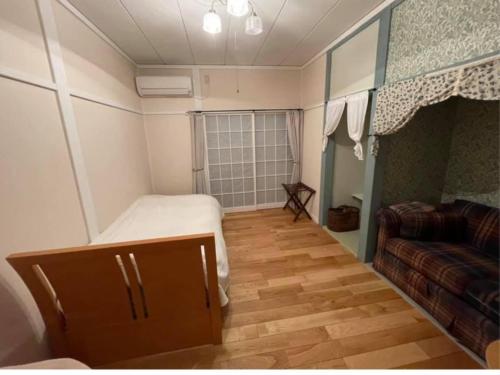 a small room with a bed and a couch at B&B Ladies Only Grape mama Grape room - Vacation STAY 11649 in Koshu
