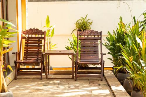 two chairs and a table on a patio with plants at Travellers Inn in Phumĭ Réach Born