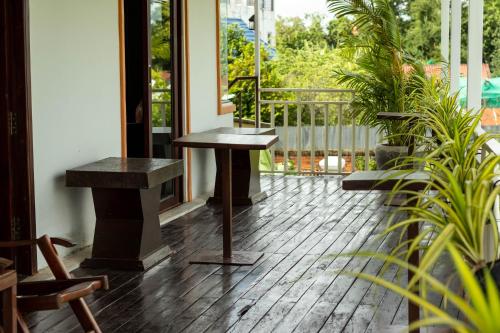 a table and bench on a porch with plants at Travellers Inn in Phumĭ Réach Born
