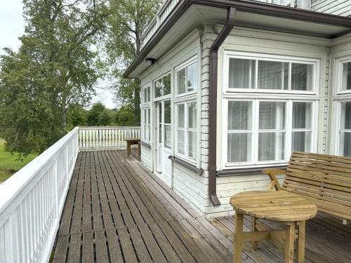 a wooden deck with a bench on a house at Atpūtas komplekss "Ratnieki" in Ratnieki