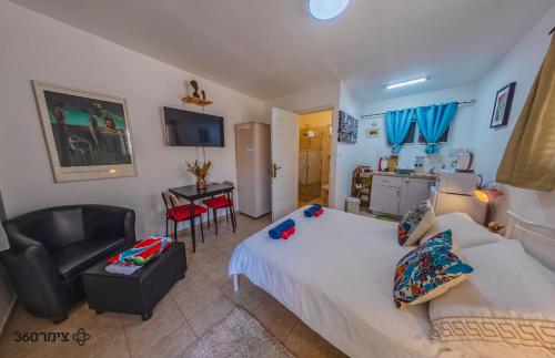 a bedroom with a bed and a chair and a table at The Lowest Place on Earth B&B in Neʼot HaKikar