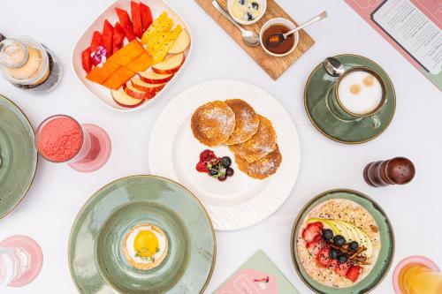 a table with plates of breakfast foods and a cup of coffee at Padmaa Jaipur in Jaipur