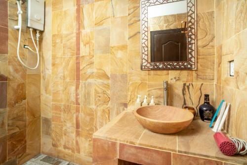 a bathroom with a wooden sink and a mirror at Travellers Inn in Phumĭ Réach Born