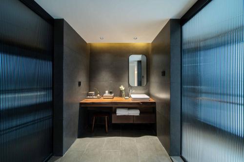 a bathroom with a sink and a mirror at Dujiangyan Irrigation Project Puruna Hot Spring Hotel Panda Valley Store in Dujiangyan