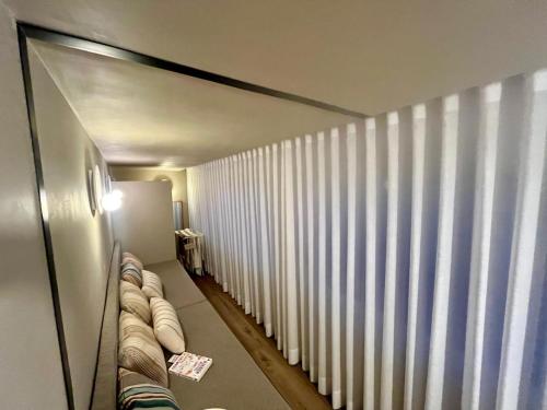 a room with white vertical blinds on a window at 903 by the sea in Sesimbra