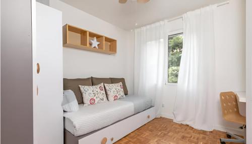 a small white room with a couch and a window at Urban Vedruna in Zaragoza