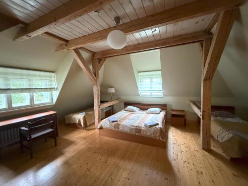 an attic bedroom with a bed and a desk at Atpūtas komplekss "Ratnieki" in Ratnieki