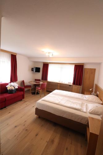 a bedroom with a bed and a living room with a table at Bruggerhof - Camping, Restaurant, Hotel in Kitzbühel
