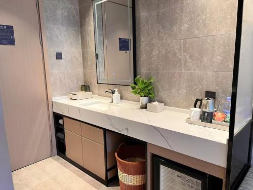 a bathroom with two sinks and a mirror at Urbain S Hotel, Xiamen Railway Station Mingfa Commercial Plaza in Xiamen