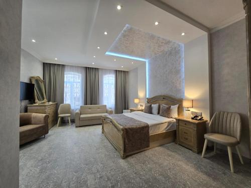 a bedroom with a bed and a couch and a chair at Sands of Time Apart Hotel in Baku