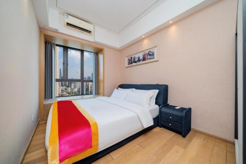 a bedroom with a large bed with a window at Heefun International Apartment - Free Shuttle to Canton Fair in Guangzhou