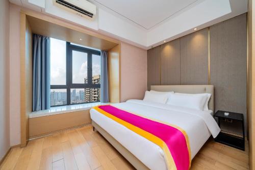 a large bed in a room with a large window at Heefun International Apartment - Free Shuttle to Canton Fair in Guangzhou