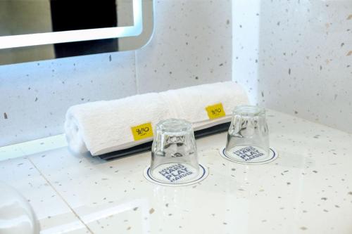 two wine glasses sitting on a counter in a bathroom at Yello Hotel Samarinda in Samarinda